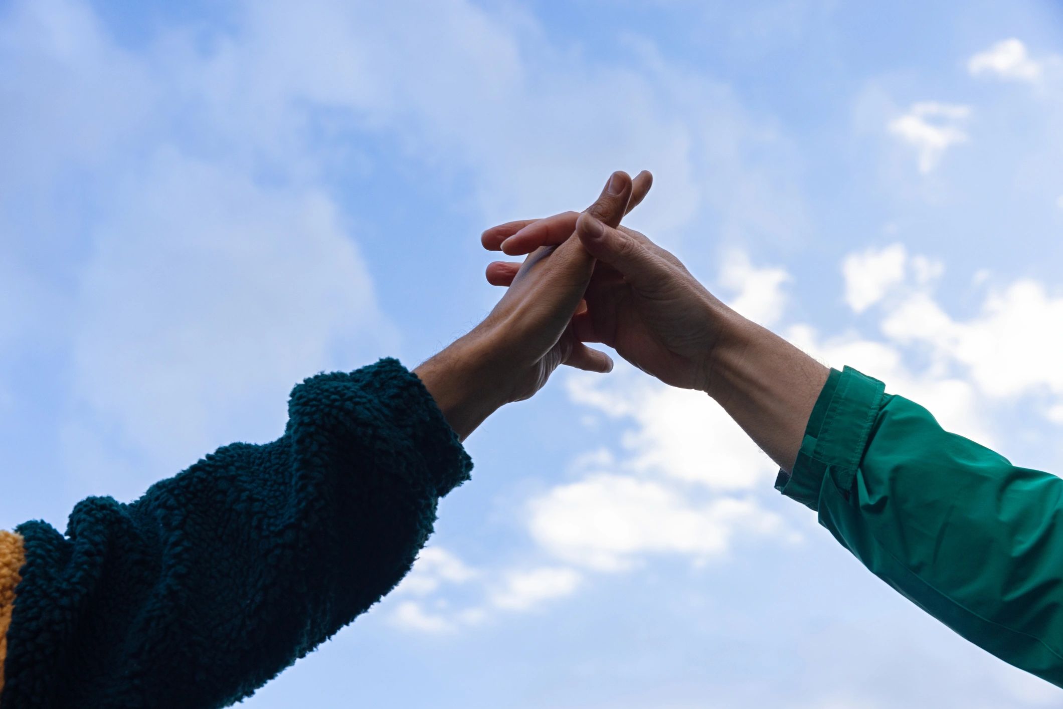 Two people holding hands symbolizing community support