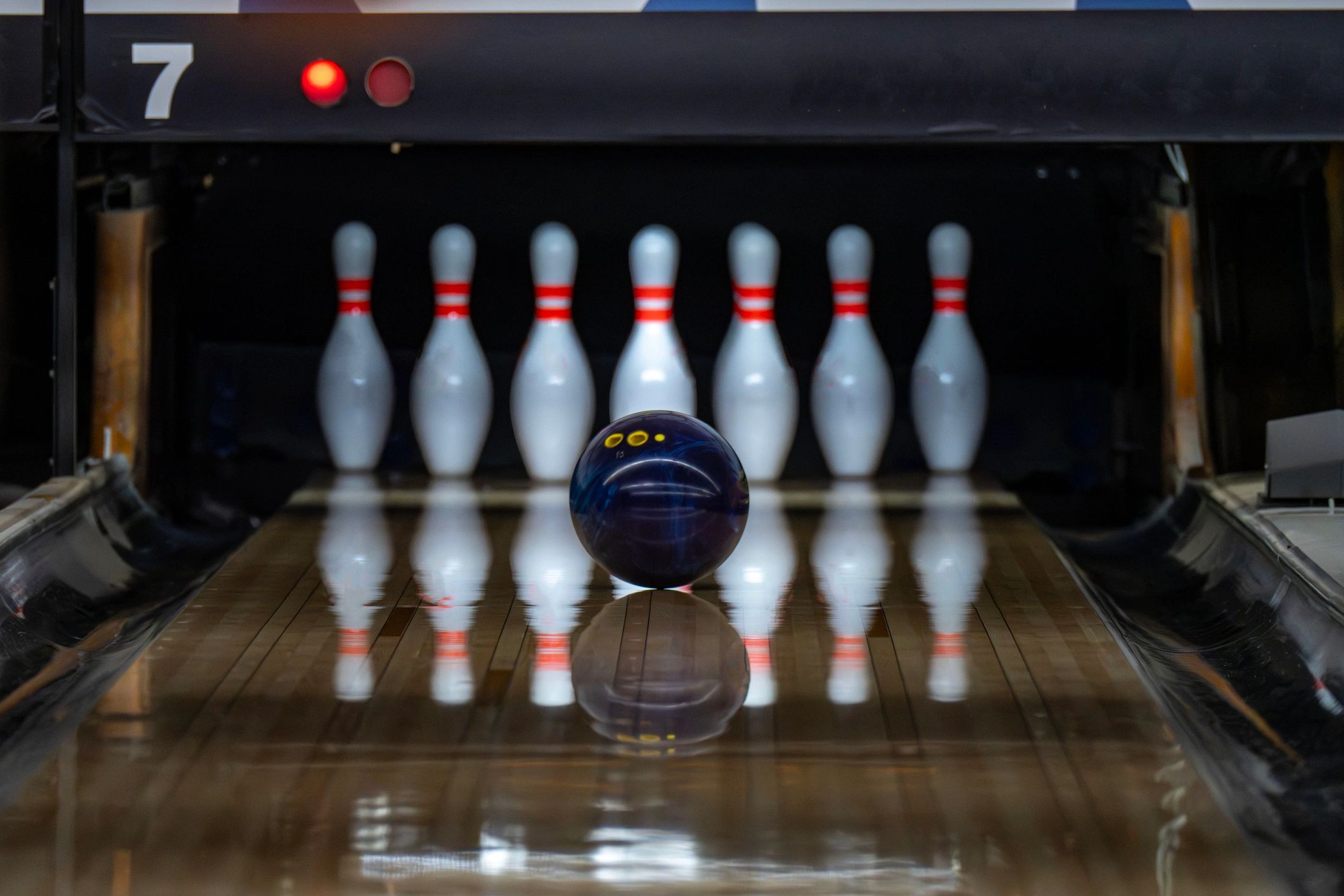 A bowling ball approaching pins on a lane