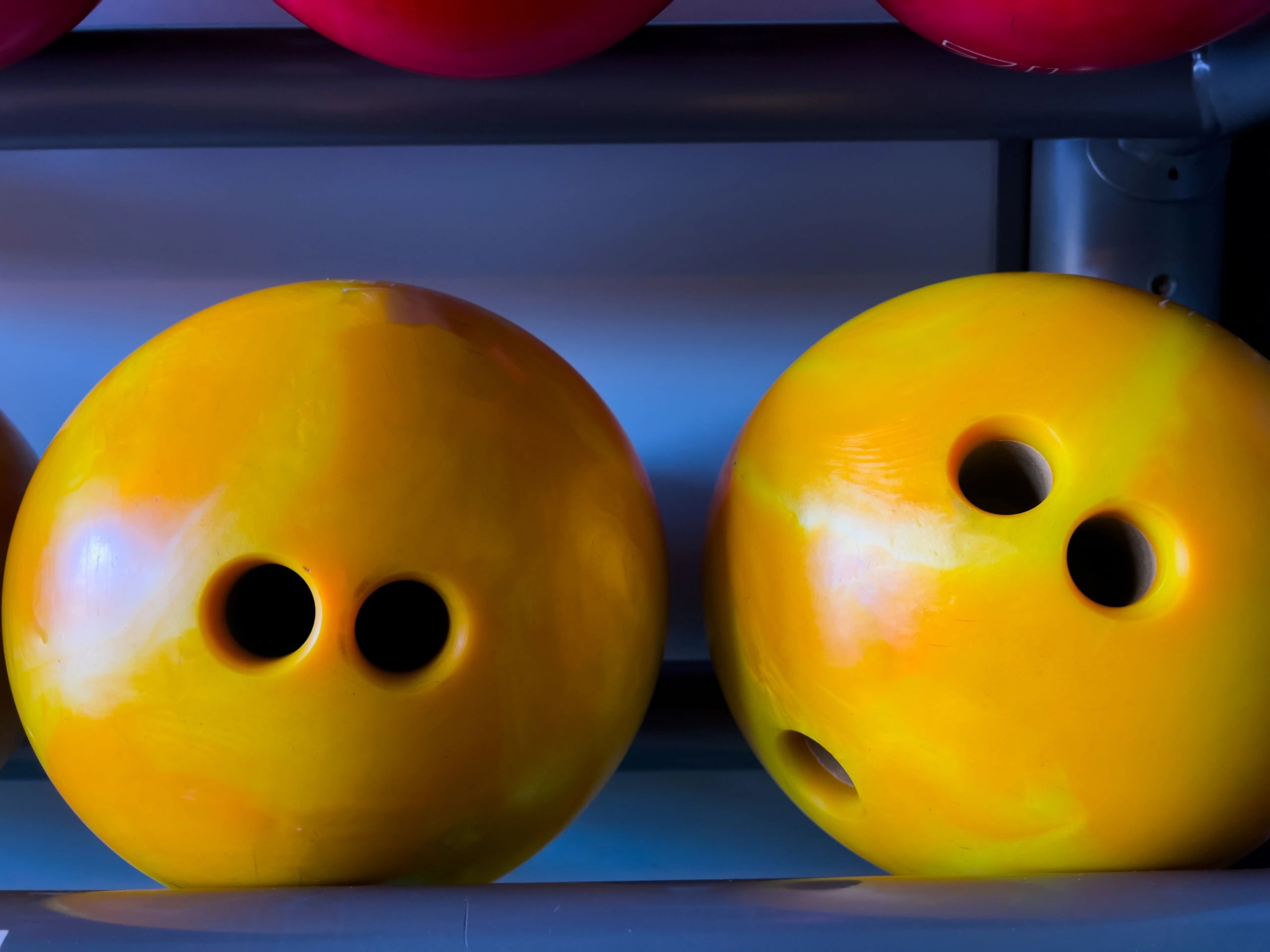 Colorful bowling balls on a rack at a bowling alley